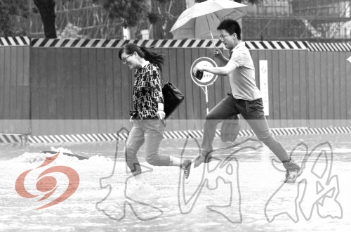 鄭州經(jīng)三路與北環(huán)交叉口處，積水較深，行人們不得不“練輕功”。 記者 白周峰 攝影