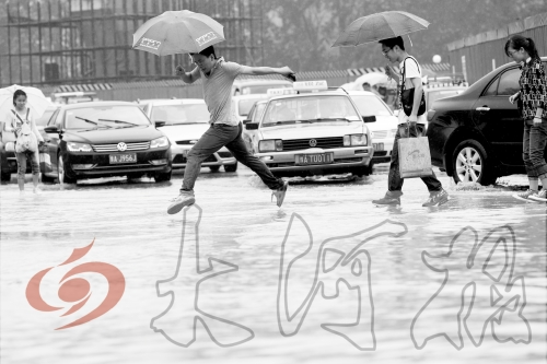 鄭州經(jīng)三路與北環(huán)交叉口處，積水較深，行人們不得不“練輕功”。 記者 白周峰 攝影