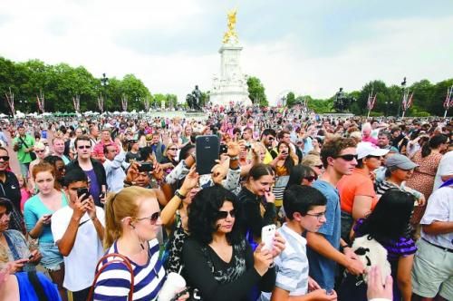 7月23日，在英國倫敦白金漢宮外，民眾們爭相閱讀“王室寶寶”出生的正式公告。