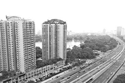 昨日，人濟(jì)山莊小區(qū)，與其他樓相比，B棟樓頂層天臺上違規(guī)建造了一棟兩層小樓，假山大樹俱全。新京報記者