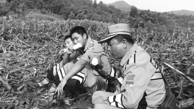 饑餓難忍，中國緊急救援河南基地的救援隊(duì)員在已毀的玉米地里撿拾生玉米吃。