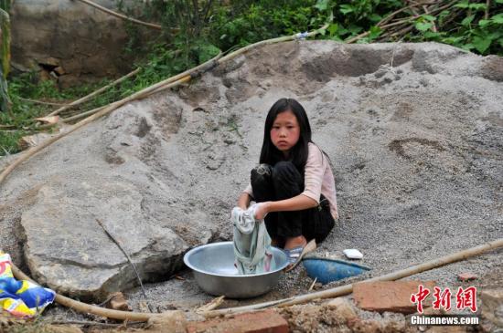 8月9日，云南巧家紅石巖村，10歲的劉鑫蕊在洗自己的衣服