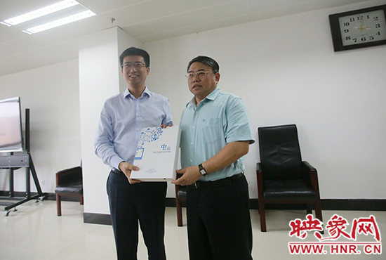 阿里云計(jì)算總裁胡曉明向河南省新聞出版廣電局局長(zhǎng)朱夏炎遞交《中原云平臺(tái)交付手冊(cè)》。