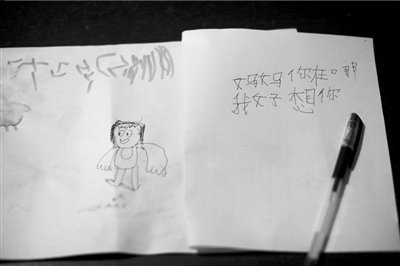 名叫袁明燕的小姑娘用筆在紙上不斷寫“媽媽”二字。