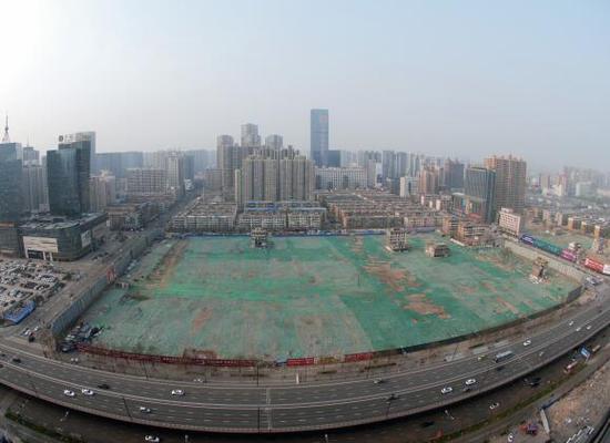 2016年4月，經(jīng)過持續(xù)攻堅，親賢社區(qū)西北片區(qū)的拆遷工作基本告一段落，但在鋪設(shè)了防塵綠網(wǎng)的空地中，至今仍有3戶居民選擇了“堅守”。(拍攝：2016年4月4日)