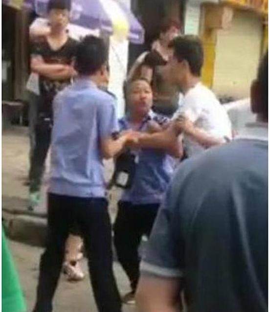 付某（右）與城管執(zhí)法人員廝打在一起。