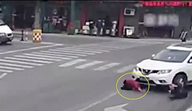 圖為小姑娘被卷進(jìn)車輪下瞬間。