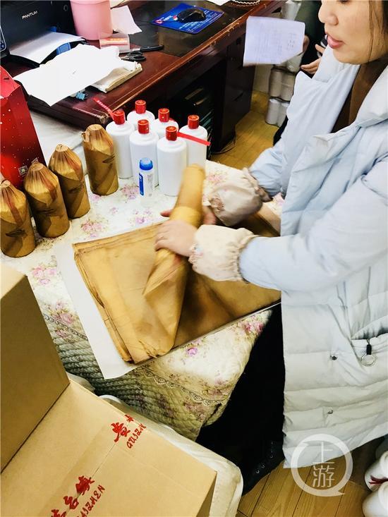 正在對(duì)白酒進(jìn)行包裝處理的經(jīng)營(yíng)戶。