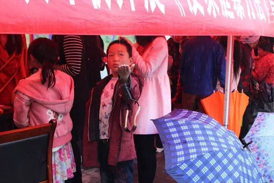 因為雨下的太大，小男孩玩起了接水游戲。