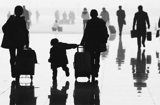 昨日，鄭州東站，一名孩子拉著媽媽和包裹快樂地奔走在春運(yùn)的途中