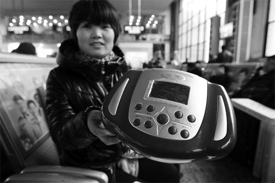 火車站候車室，李女士向記者展示她準(zhǔn)備孝敬父母的按摩儀