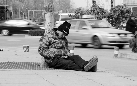 2月2日，鄭州市中州大道農(nóng)業(yè)路立交橋下，50歲的王文德打算在臨近春節(jié)前再接些零活兒，由于疲憊，他睡著