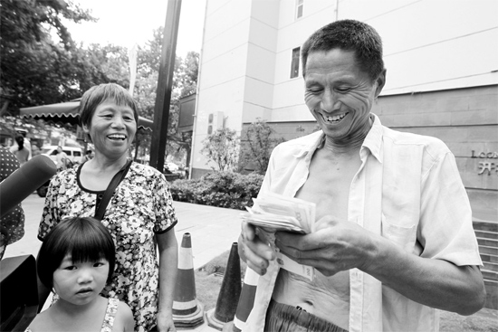 昨日，鄭州市明達路與豐慶路交叉口西300米路南，來自中牟的瓜農(nóng)拿到西瓜款，笑開顏東方今報記者袁曉強