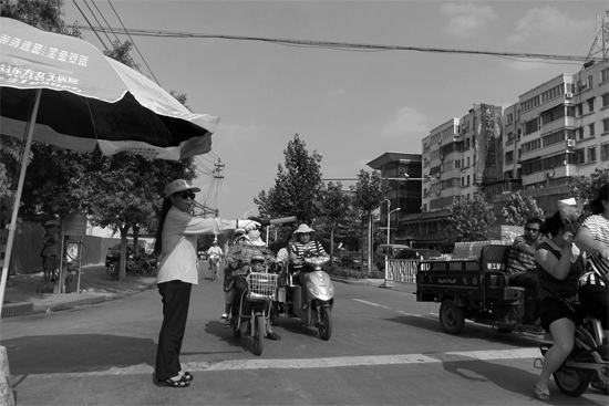 昨日，開封市區(qū)一名協(xié)管員在指揮群眾過(guò)馬路