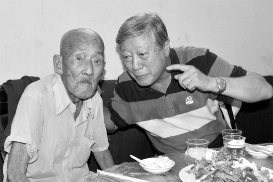 昨日，來自北京的英雄后代胡冠軍（右）專門趕到西平縣看望抗戰(zhàn)老兵孫殿修老人