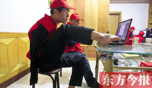 12月2日，一名“豫殘聯(lián)盟”志愿者正通過網(wǎng)絡(luò)、微博等聯(lián)絡(luò)著各地殘疾人朋友 東方今報首席記者 張曉冬