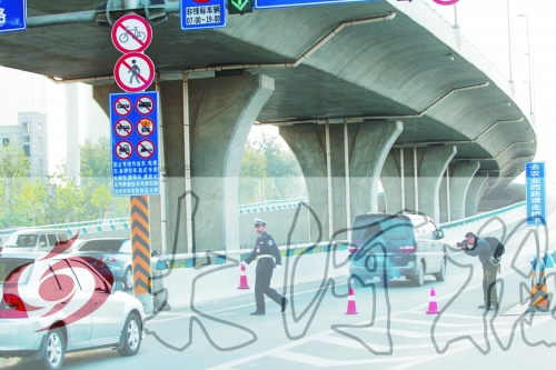 交警在東風(fēng)路從北向南上橋口處擺上反光錐，間歇放行