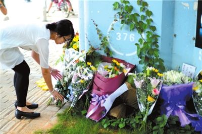 6月8日下午，記者來到廈門公交車爆炸事發(fā)現(xiàn)場橋下，附近已聚集了十幾個自發(fā)前來悼念的市民。橋墩下排放了一圈或黃或白的菊花，還有玖瑰、百合等。