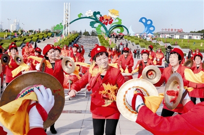 在中國(guó)國(guó)花園，伊川縣威武龍鼓藝術(shù)團(tuán)的精彩表演吸引眾多游客