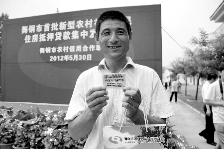 領(lǐng)到貸款，農(nóng)民開心地笑了。