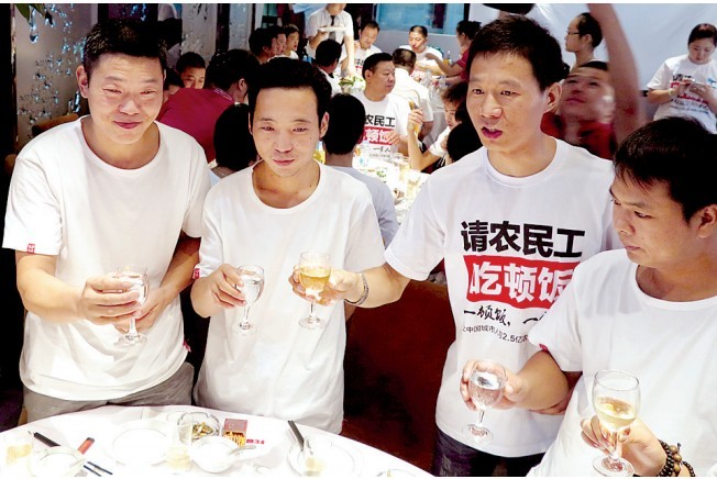 活動(dòng)發(fā)起人張楠（右二）給農(nóng)民工敬酒。