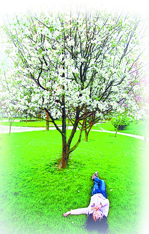 　孩子愜意地躺在社區(qū)內(nèi)的草坪上。