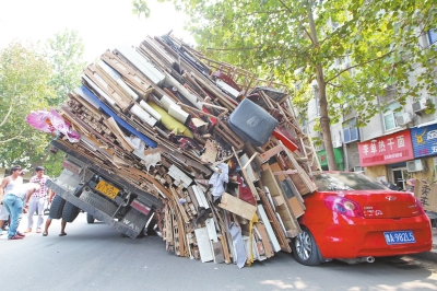 紅色小轎車(chē)被砸，卡在路邊動(dòng)彈不得。