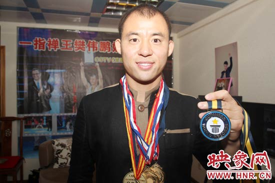 樊偉鵬向大家展示自己剛獲得的吉尼斯獎(jiǎng)牌。