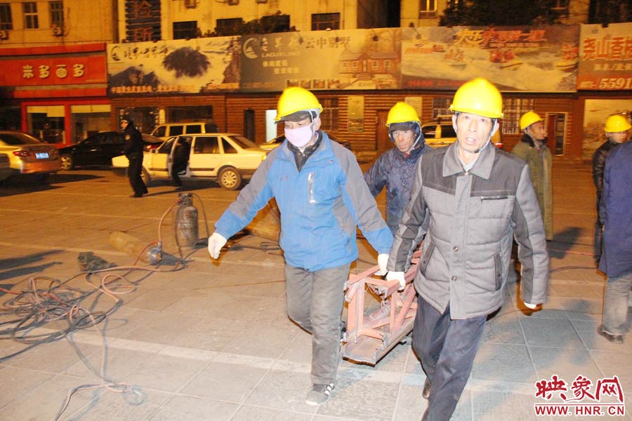 23點56分，第一塊兒廣告牌已經(jīng)分割完畢，地面上的20多名工人將拆除下來的鋼件撞車運走。