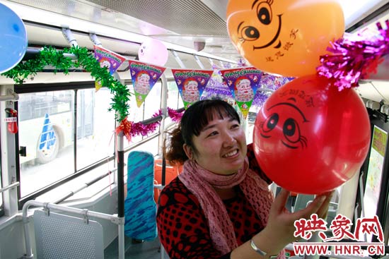 鄭州快速公交B3區(qū)間線車長李鵬云在車廂里懸掛氣球，布置圣誕車廂，營造歡樂圣誕氛圍