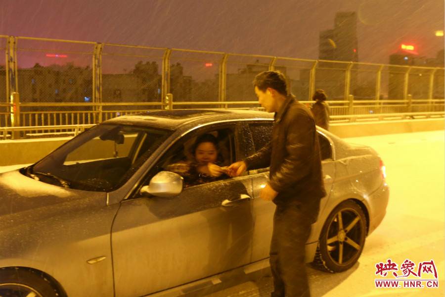 “推車人”幫助一輛車上坡后，收取“勞務(wù)費(fèi)”。