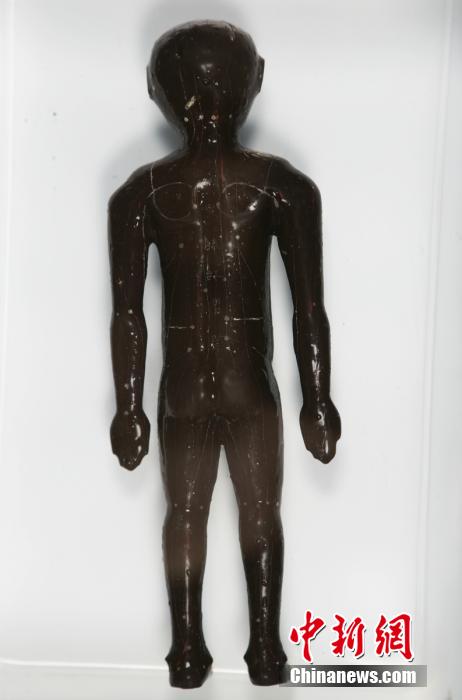 圖為出土的人體經(jīng)穴漆俑。