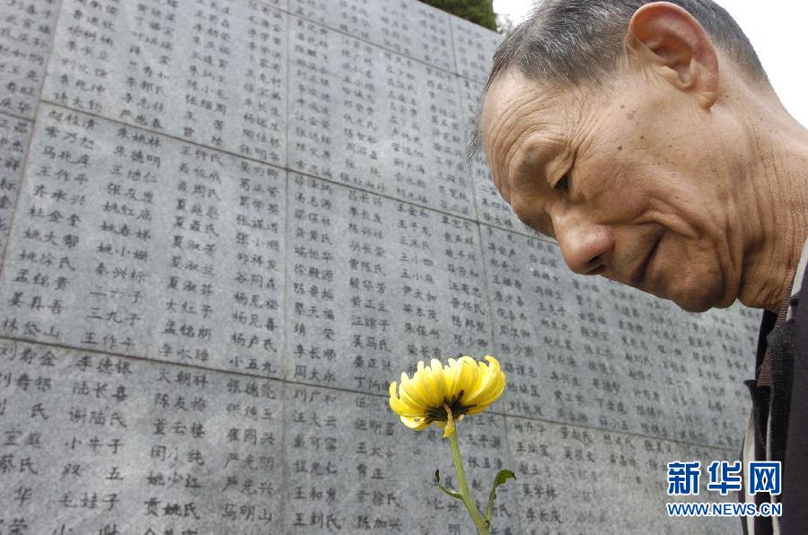 2006年4月5日，74歲的南京大屠殺幸存者佘子清手捧鮮花，祭奠被日軍殺害的母親。