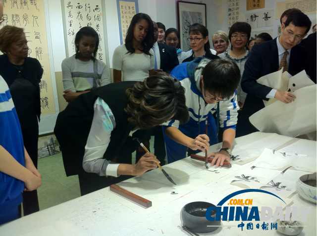 　北京時間3月21日，美國第一夫人米歇爾參觀北師大二附中時，與學(xué)生一起練習(xí)書法。