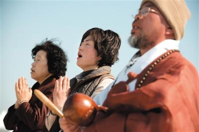 23日，一名僧侶引領(lǐng)人們?yōu)樗勒咂矶\。