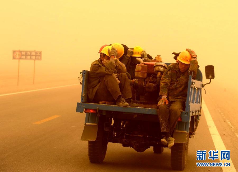 4月23日，一輛拉載公路施工人員的三輪車在沙塵暴中行駛在酒泉市瓜州縣城郊的公路上。