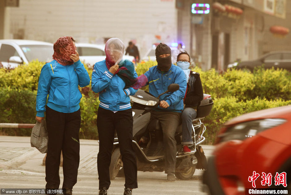 2014年04月23日，新疆維吾爾自治區(qū)吐魯番地區(qū)，市民戴著口罩行走在大風沙塵中的吐魯番市街頭。