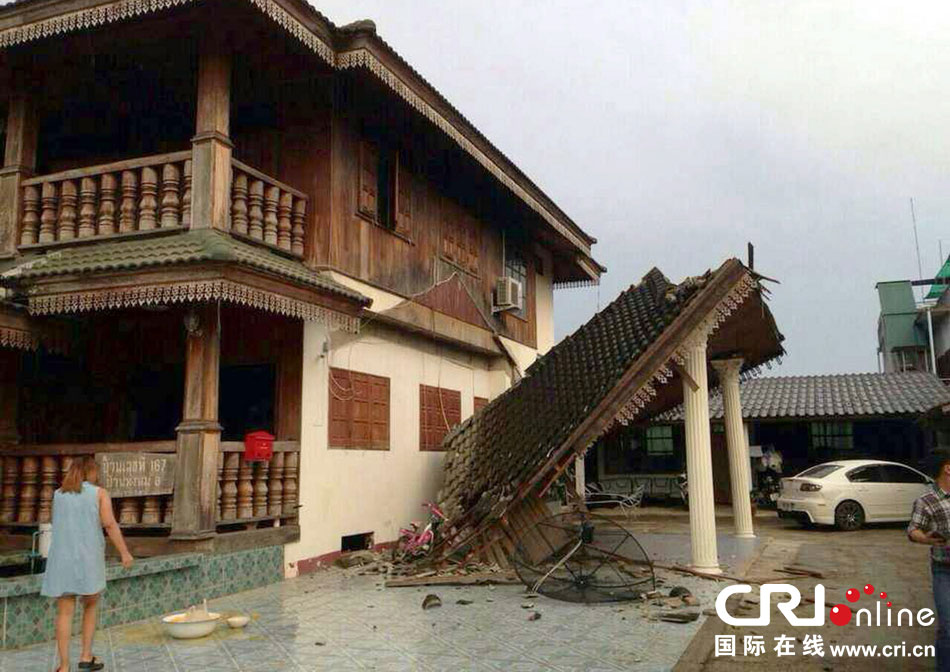 當?shù)貢r間2014年5月5日，泰國清萊，一名婦女看著受損的房屋。 圖片來源：東方IC