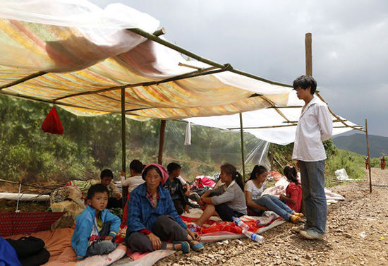 暴雨馬上來臨，村民們在簡易帳篷下躲雨。澎湃新聞 程藝輝 圖