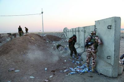 埃爾比勒郊外的一個(gè)檢查站附近,武裝組織成員躲避在掩體后 埃爾比勒郊外的一個(gè)檢查站附近,武裝組織成員躲避在掩體后