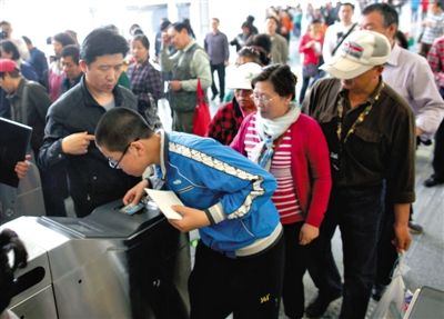 去年5月5日，14號線園博園站，乘客刷卡出地鐵。北京公交地鐵將實(shí)行計(jì)程票制，多乘坐多付費(fèi)。