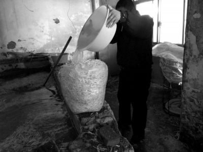 作坊內(nèi)工人用攪拌有漂白粉的藥水給豆芽增白。