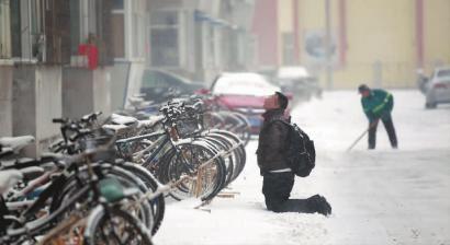 小伙子跪在樓前，一直抬頭看著樓上。 孫立國(guó)/攝