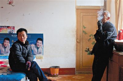 父親抽煙，兒子不語。逃跑的越南新娘，給袁迎賓父子帶來的是失落。新京報記者