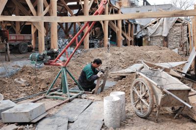 東城區(qū)北鑼鼓巷與小經(jīng)廠胡同之間一處四合院內，工人進入已經(jīng)挖好的地下室內施工。