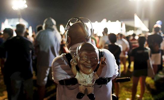 9月4日，新加坡，執(zhí)政黨的一場(chǎng)集會(huì)上，一名支持者背著一個(gè)李光耀的人偶。