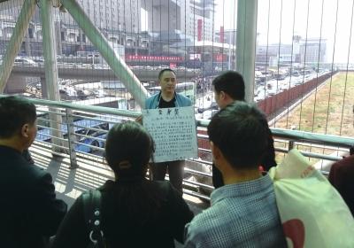 韓先生在北京西站天橋上籌錢。京華時(shí)報(bào)記者陶冉攝