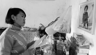 錢仁鳳站在母親遺像前。未能見母親最后一面是她的一大遺憾。