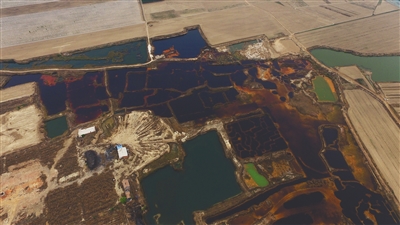 4月19日，廊坊市大城縣南趙扶鎮(zhèn)，津保路以北約八九百米處，一個巨大的污水坑中，水體呈現(xiàn)紅褐色。 新京報記者 尹亞飛 攝