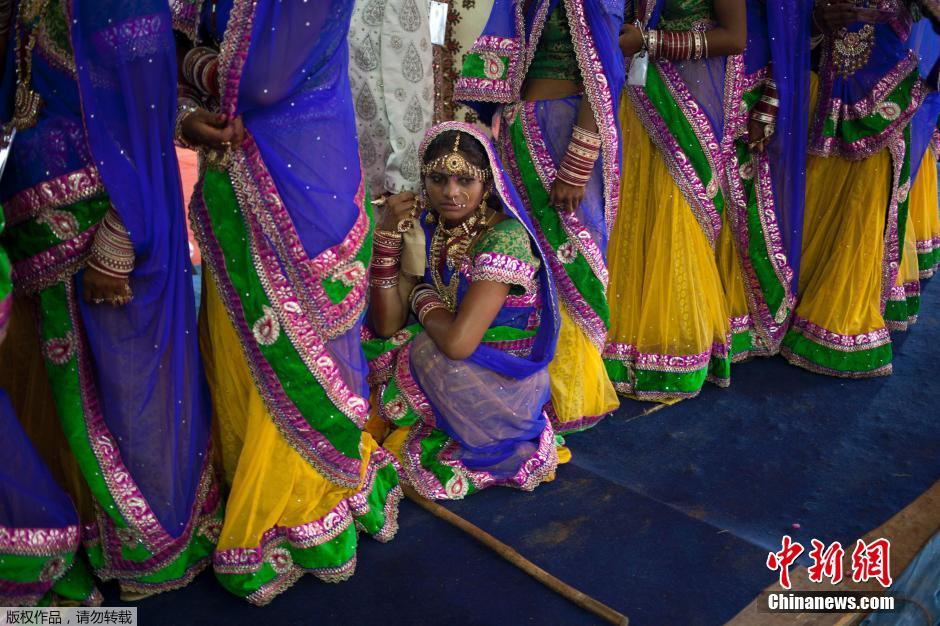 當(dāng)?shù)貢r(shí)間2014年6月15日,印度新德里,印度政府為數(shù)百對(duì)貧困新人舉辦集體婚禮。